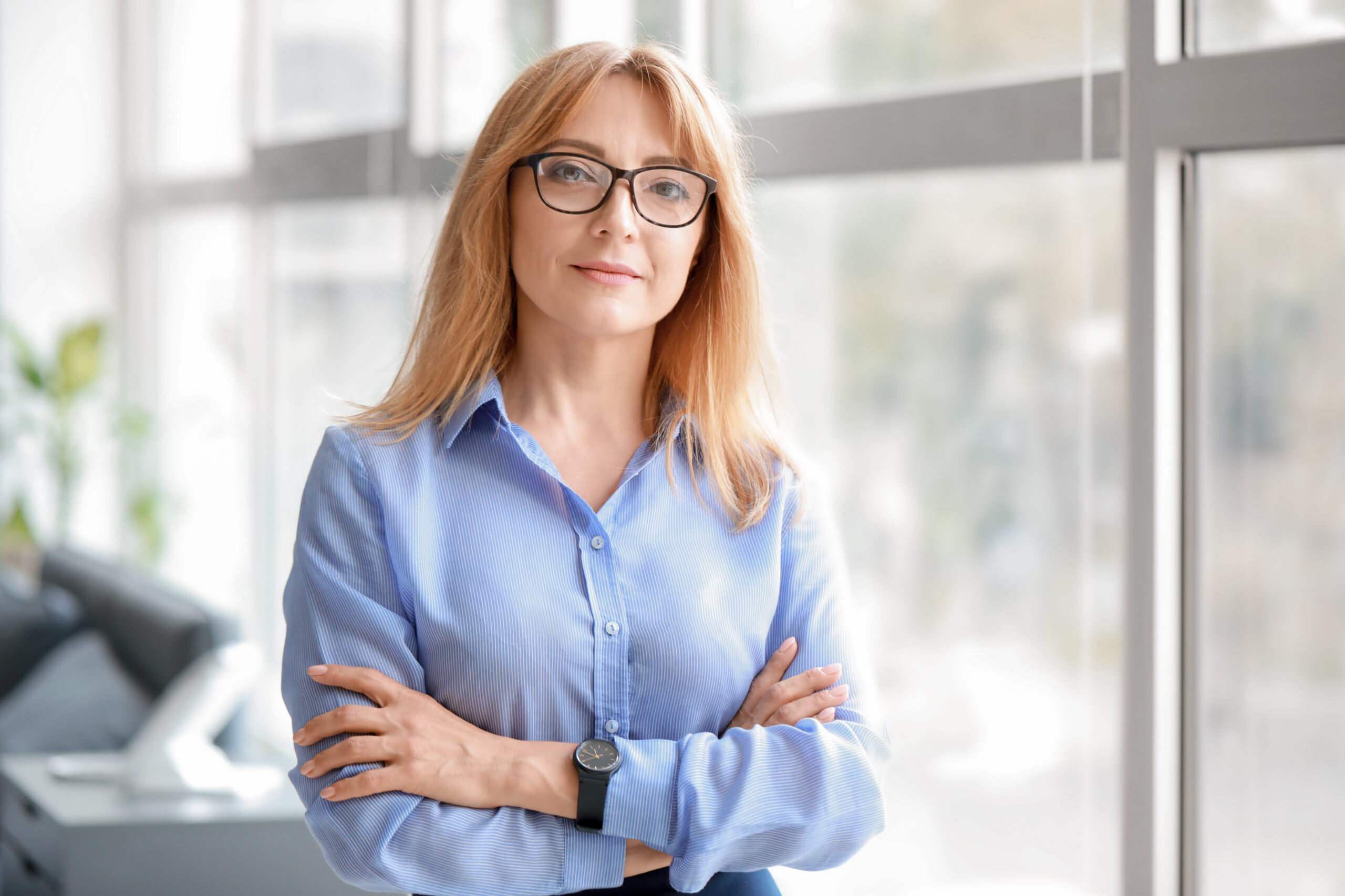 Portrait of stylish mature businesswoman near window in office