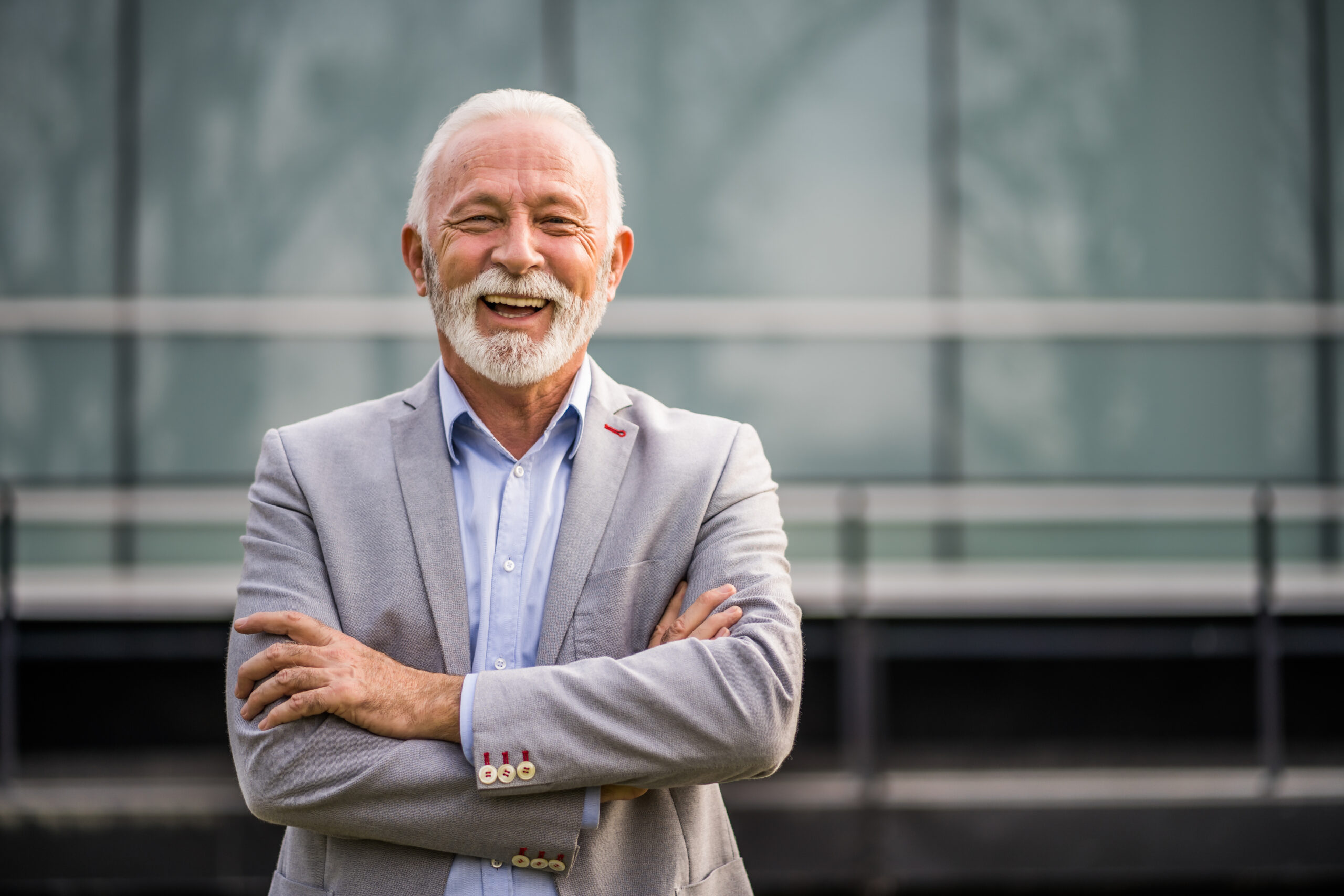 Outdoor portrait of senior businessman in front of company build